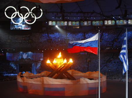 聖火とロシア国旗。次回の冬季五輪は２０１４年にロシアのソチで開催.jpg